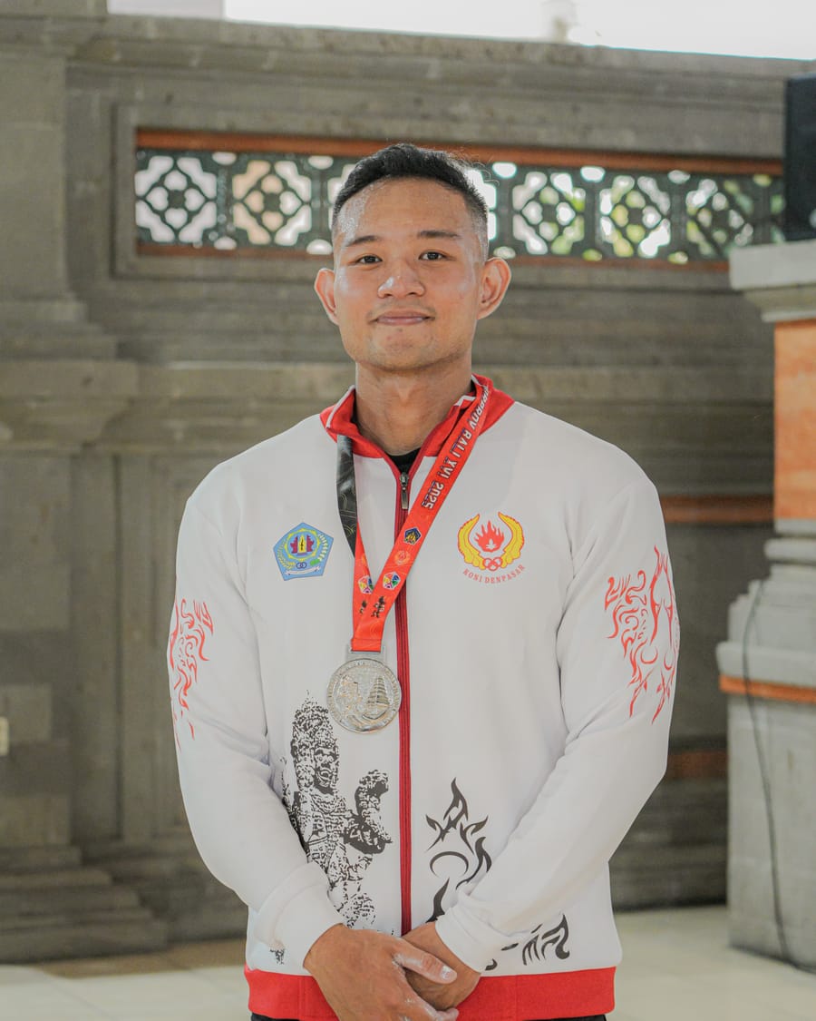 Jasson Thio wearing his Denpasar team jacket and PORPROV Bali powerlifting medal